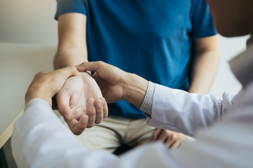 Patient receiving pulse check from doctor after suffering a personal injury.