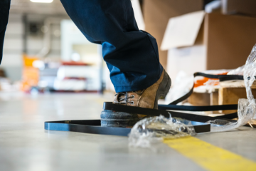 Boot caught in wires, causing person to trip and fall in the workplace.