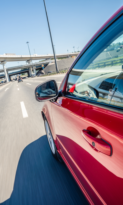 Red car speeding down the highway could cause automotive crashes.