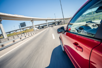 Red car speeding down the highway.