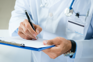 Doctor writing on clipboard.