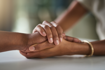 Loves one hold hands to console each other as the cope with the loss of a wrongful death.