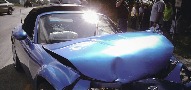 Blue convertible mangled after car crash.