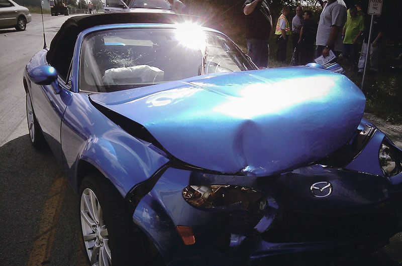 Blue convertible mangled after car crash.