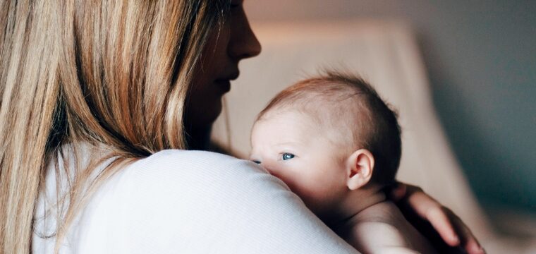 A mother holds her newborn baby with birth injuries to her chest