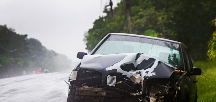 A black sedan is damaged on the side of the road after one of the most common car crashes occurred.