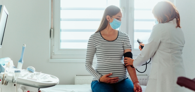 Pregnant woman having blood pressure taken to avoid negligent pregnancy care