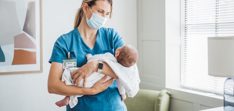 doctor holding baby after wrongful death of mother during delivery and advising they hire a birth injury lawyer