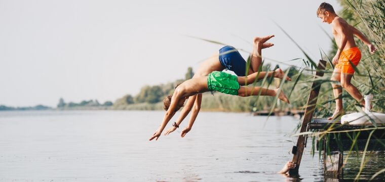 Kids diving into a lake for summer swimming.